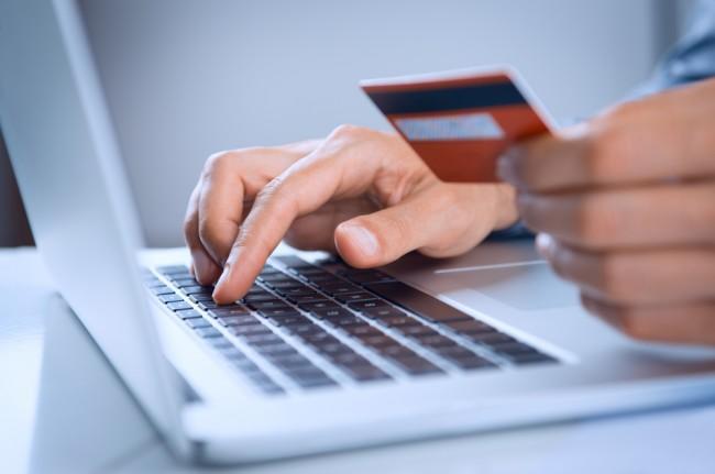 Zdjęcie Close Up Of A Man Shopping Online Using Laptop With Credit Card pochodzi z serwisu ShutterStock 
