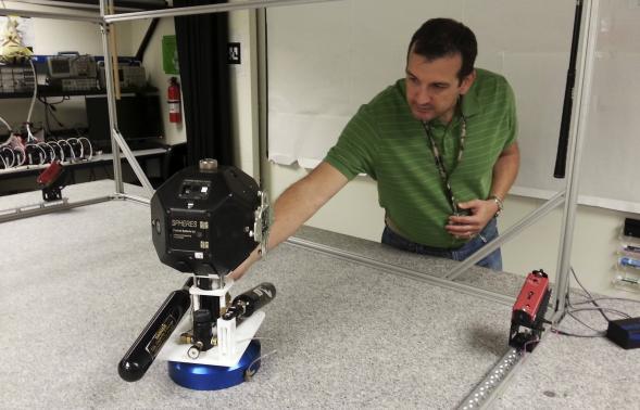 Smart SPHERES project manager Chris Provencher demonstrates one of NASA&#8217;s robots at the Ames Research Center in Mountain View, California 